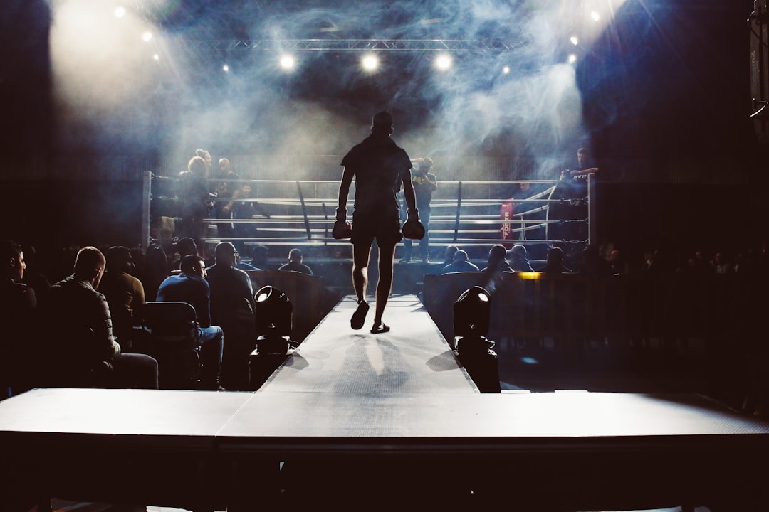 Fighter walking to the ring under arena lights before a combat sports event