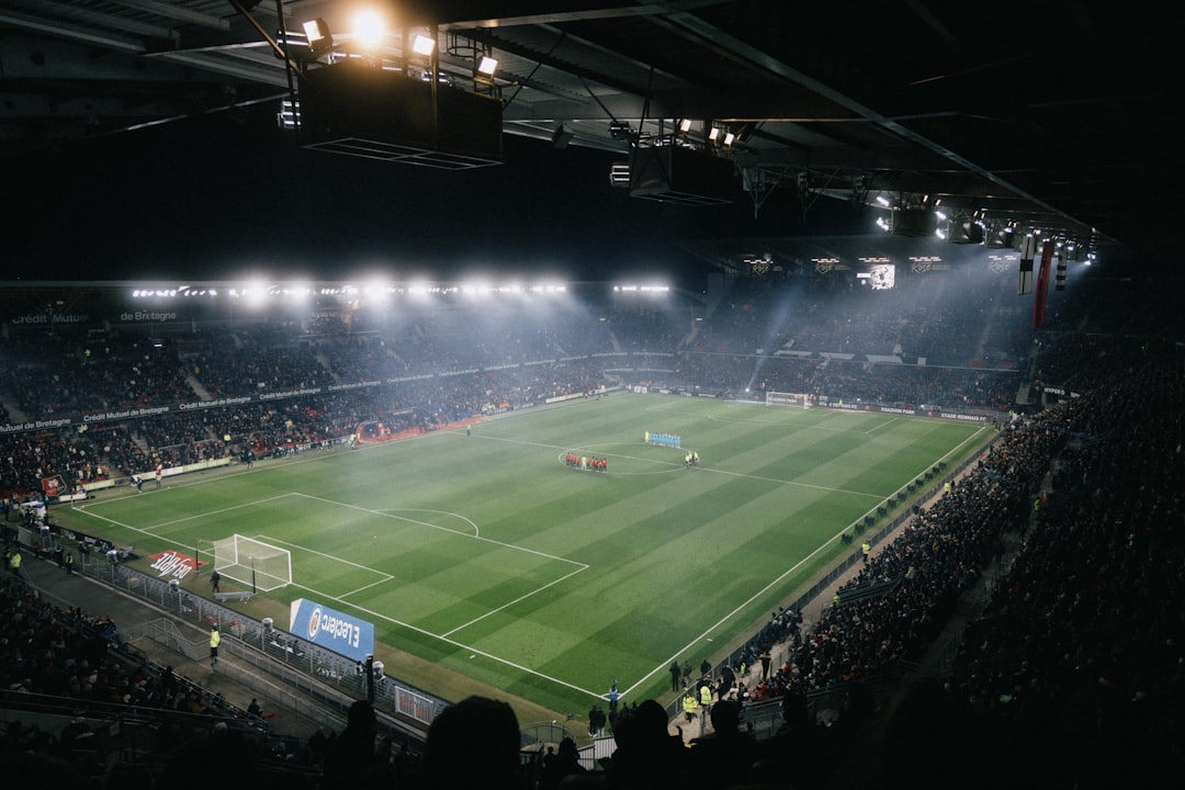 Football stadium under floodlights at night during a match