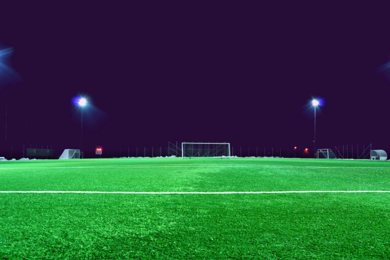 Stock photo of a green football pitch under bright floodlights at night. It is not a photograph of FNB Stadium or of a Betway Premiership match.