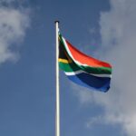 Stock photograph of the South African national flag waving against a clear blue sky. It is not a photograph of the Bafana Bafana squad, a training session or any match.