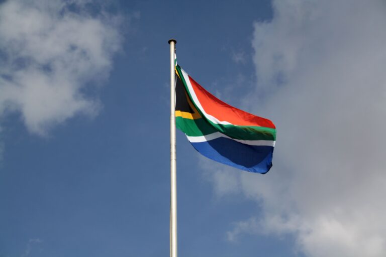 Stock photograph of the South African national flag waving against a clear blue sky. It is not a photograph of the Bafana Bafana squad, a training session or any match.