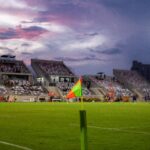 A corner flag in focus at a football ground under a dusk sky. This is a stock photograph and not Stamford Bridge.